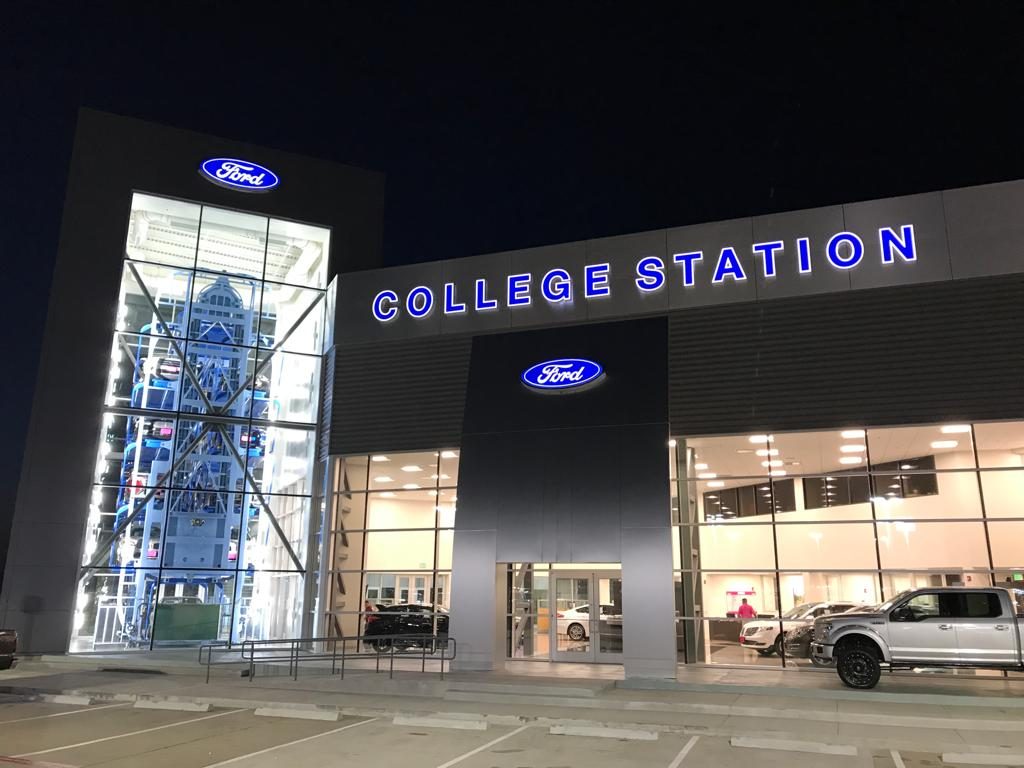 Carousel tower lit at night at the entrance of a Ford dealership in College Station, Texas