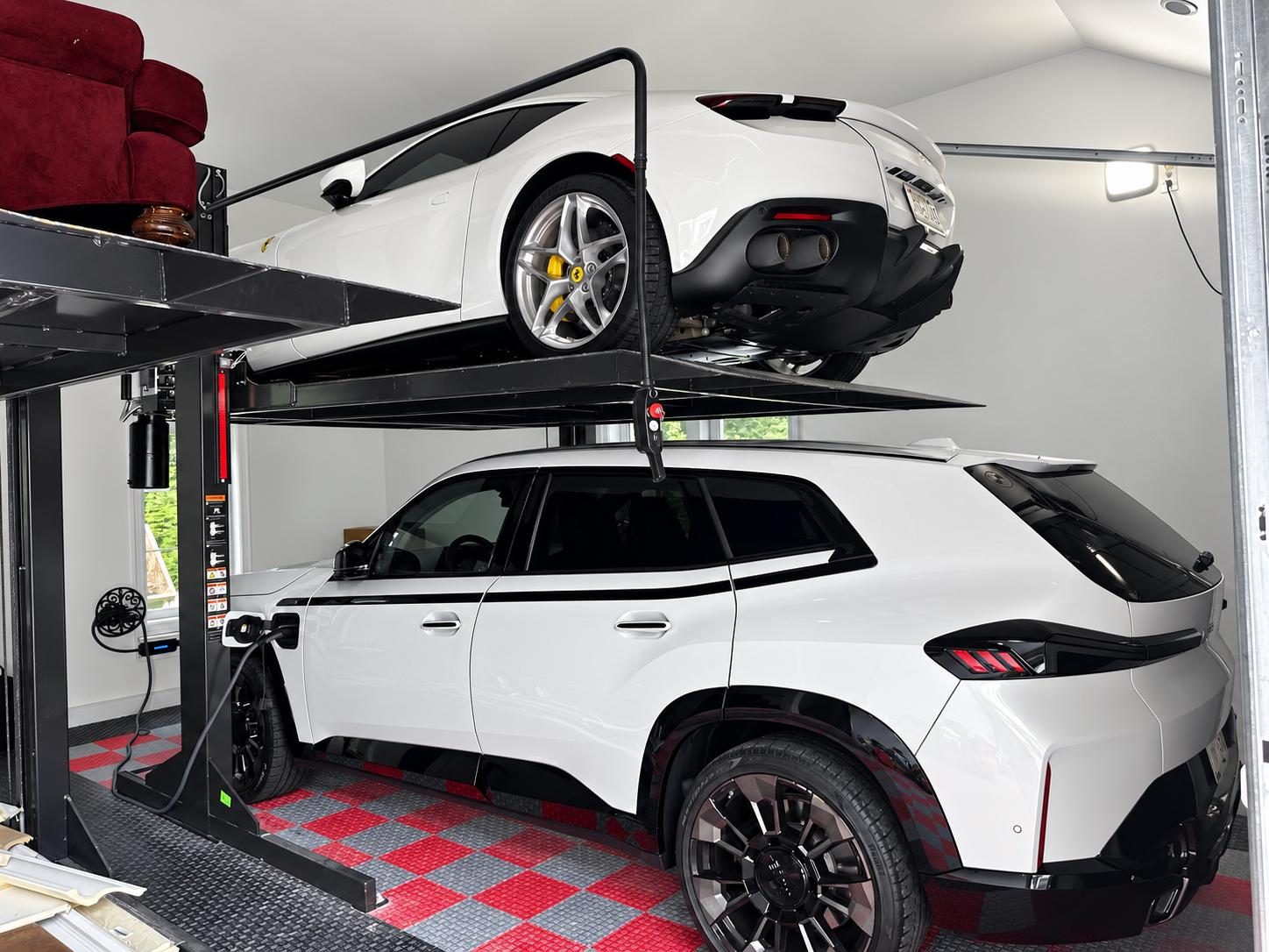 An SUV parked beneath a coupe on a Double Stacker in a home garage