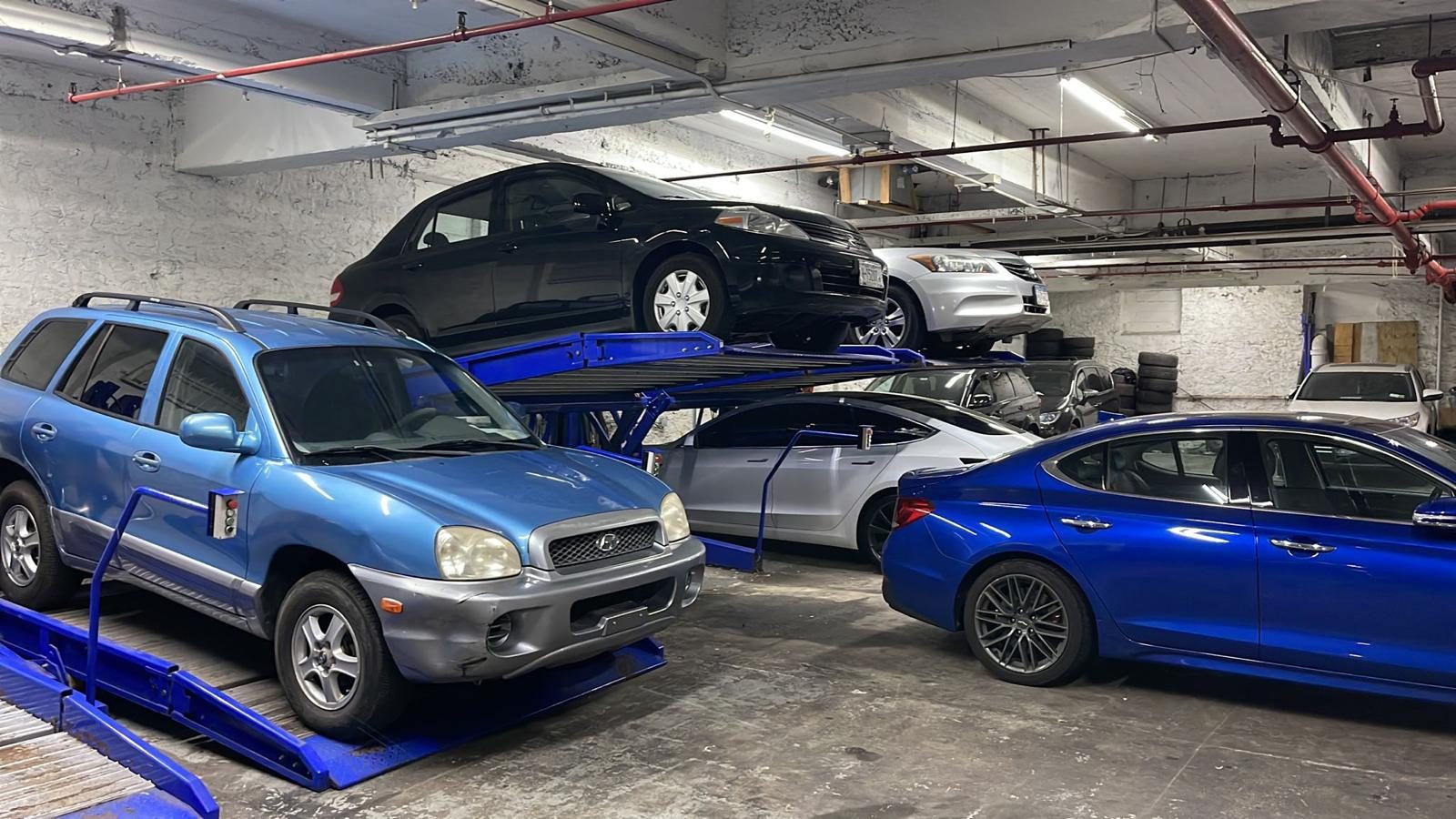 Double Stackers with blue platforms in an indoor garage in Queens