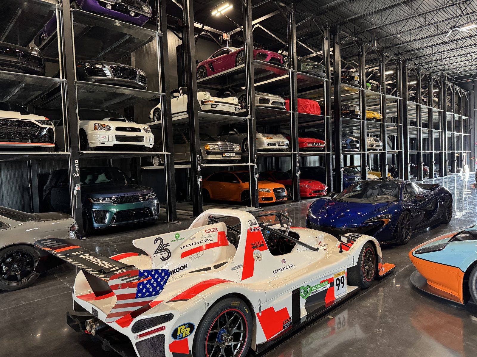 Sports cars stored four levels high on Quad stackers in a private collection warehouse