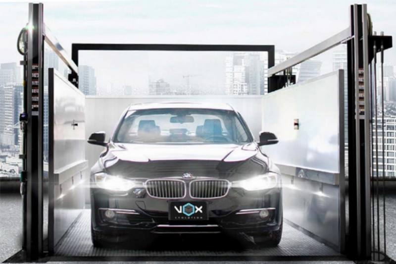 A sedan waiting in the open cabin of a Vox car elevator