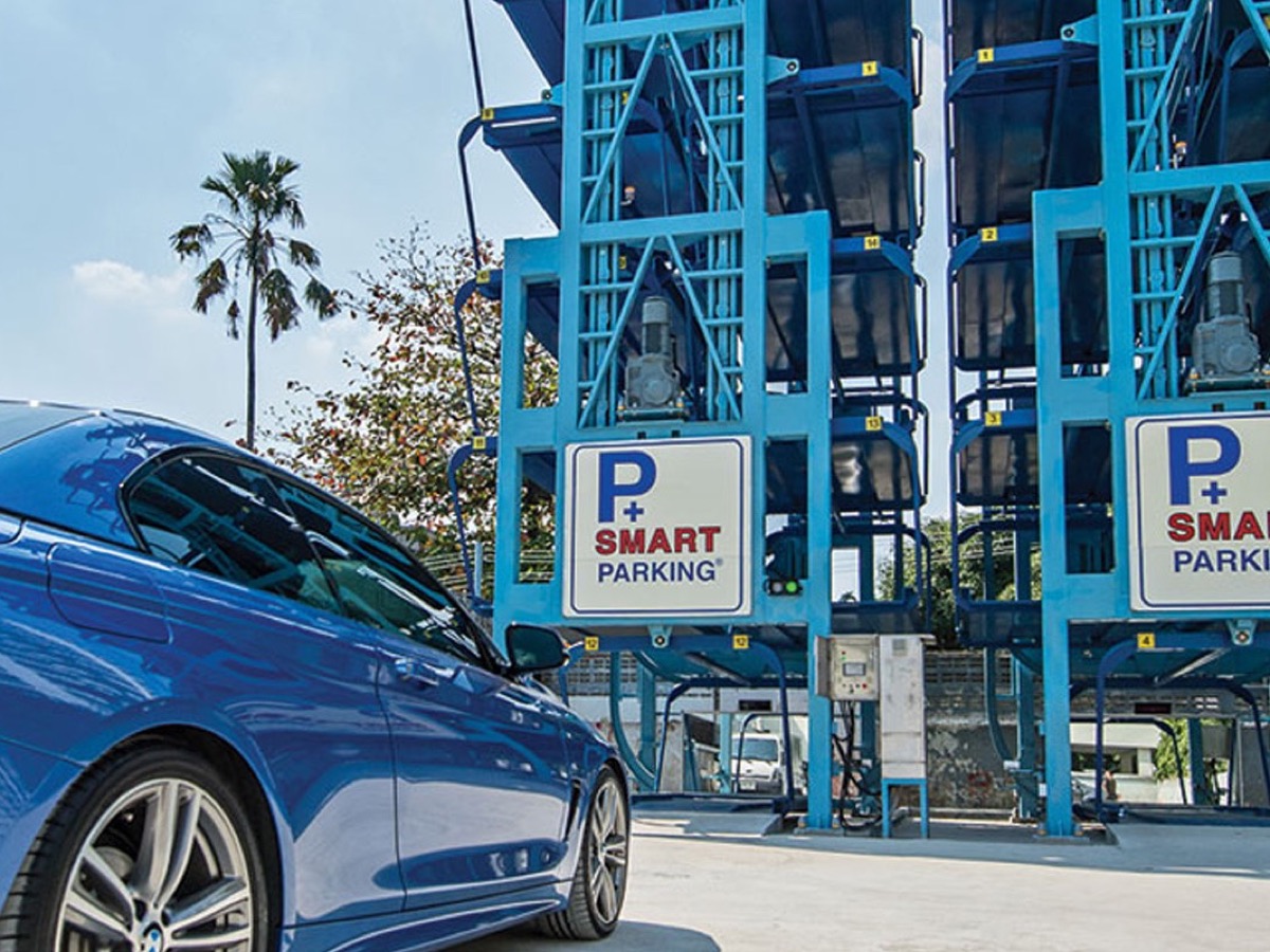 Rotary carousel parking towers on a city street with a vehicle waiting at the entry cabin