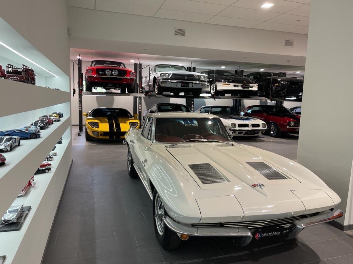 Hydraulic valet parking lifts holding vehicles above the showroom floor