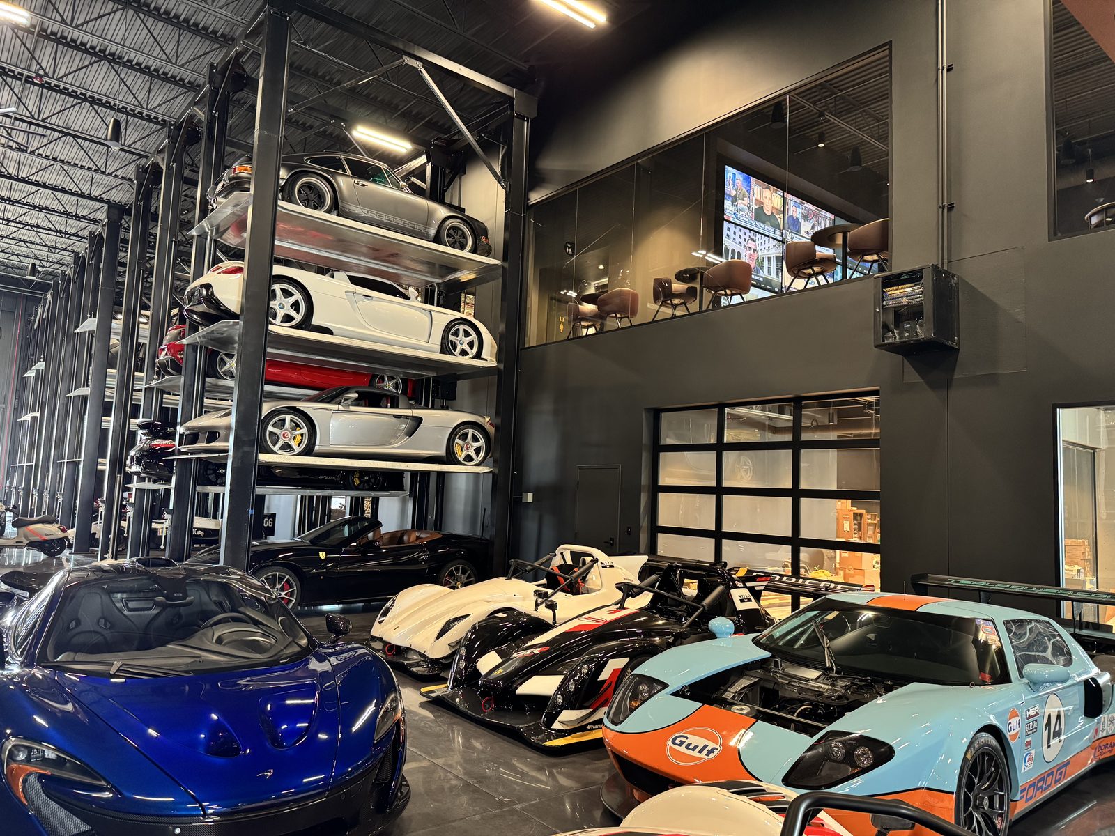 Sports and race cars in front of four-level Quad Stackers in a collector warehouse in Acton, Massachusetts