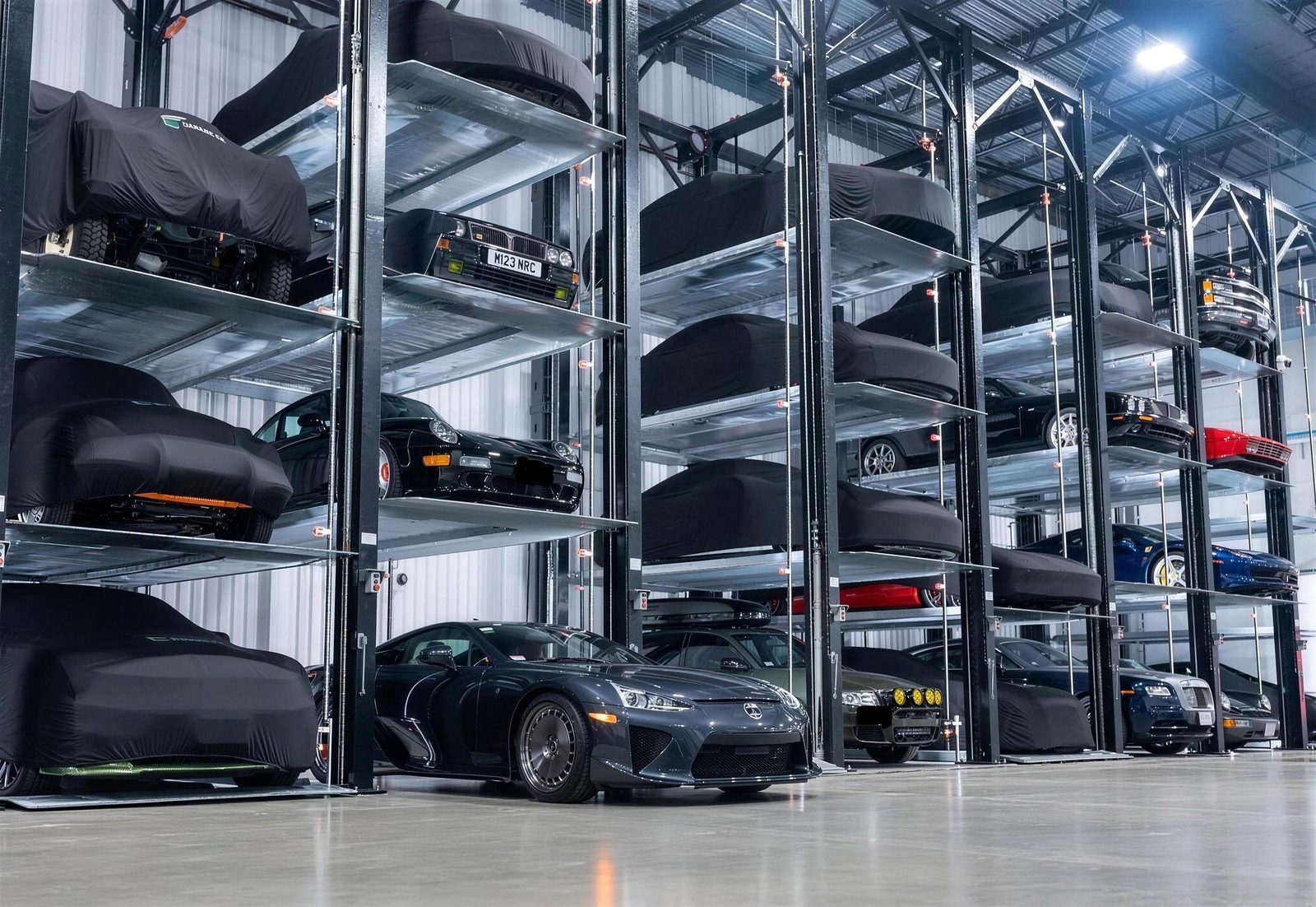 Covered rack and rail storage with vehicles on platforms across several levels